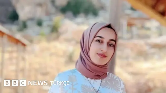 Rojin Kabaiş&#x27;in tek başına gülümseyerek kadraja baktığı bir fotoğrafı. Üzerinde beyaz bir kıyafet ve somon rengi bir başörtüsü var